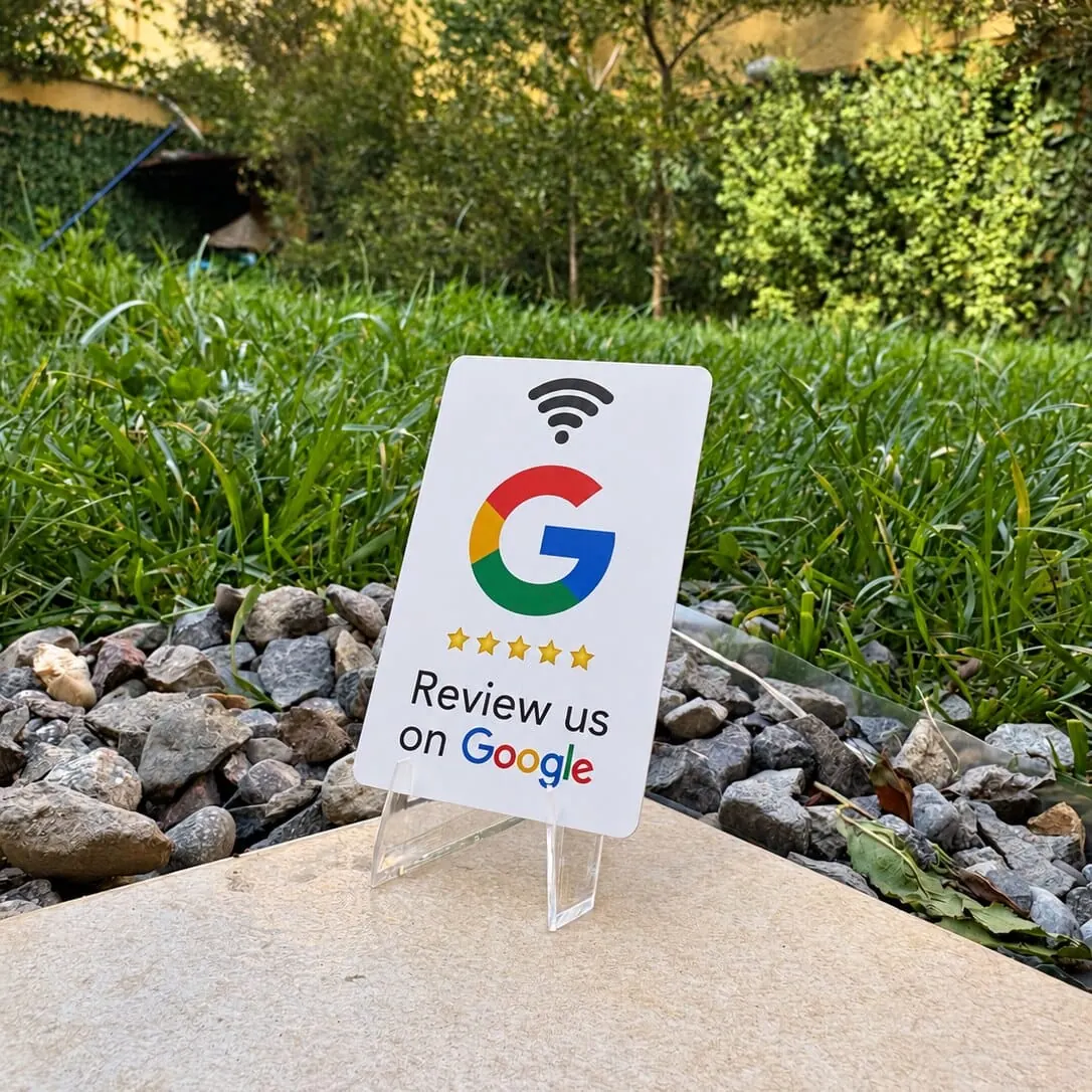 Tarjeta de reseñas de Google en su soporte de acrílico, fotografiada sobre una mesa de piedra